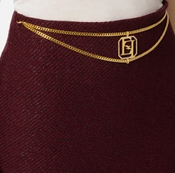 Minigonna in tweed laminato con accessorio logo