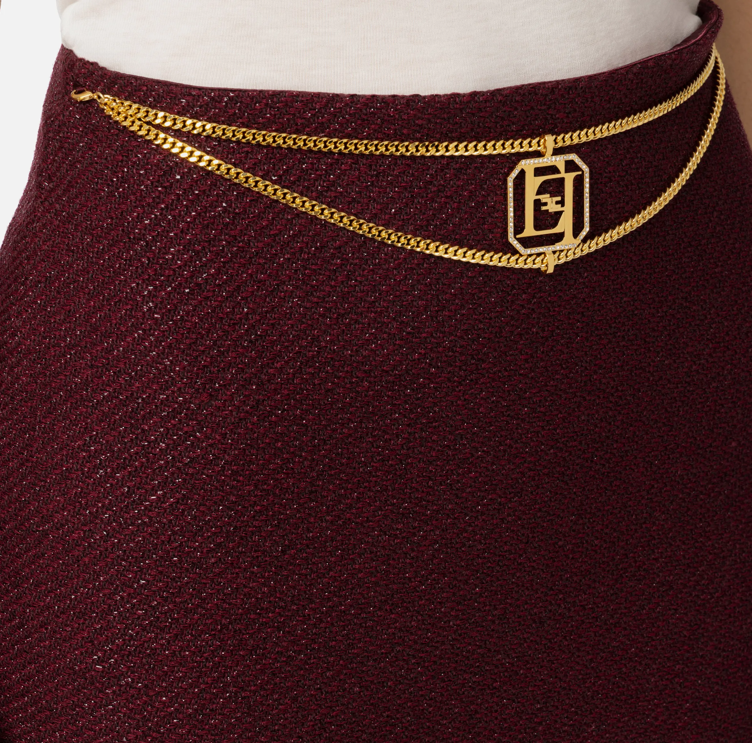 Minigonna in tweed laminato con accessorio logo